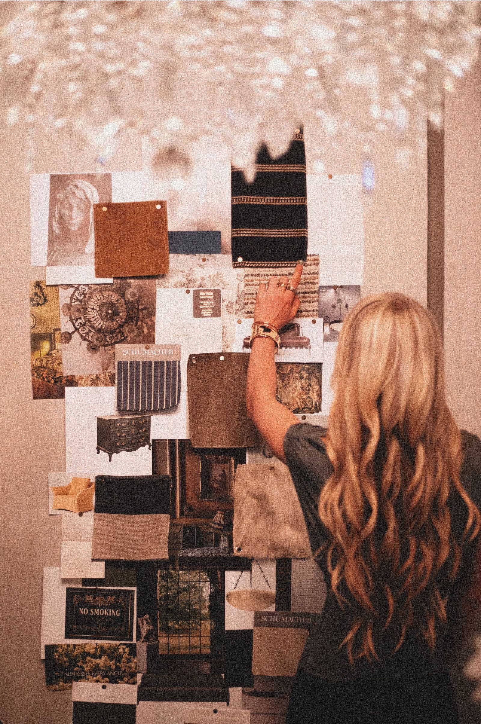 A designer pinning fabric and material samples to a mood board