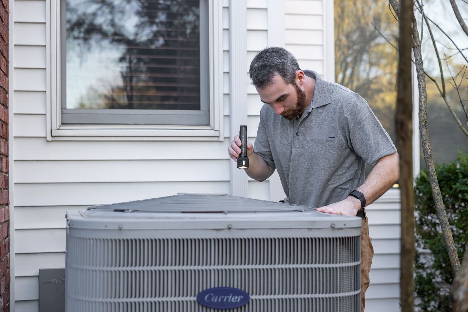A technician servicing an outdoor unit
